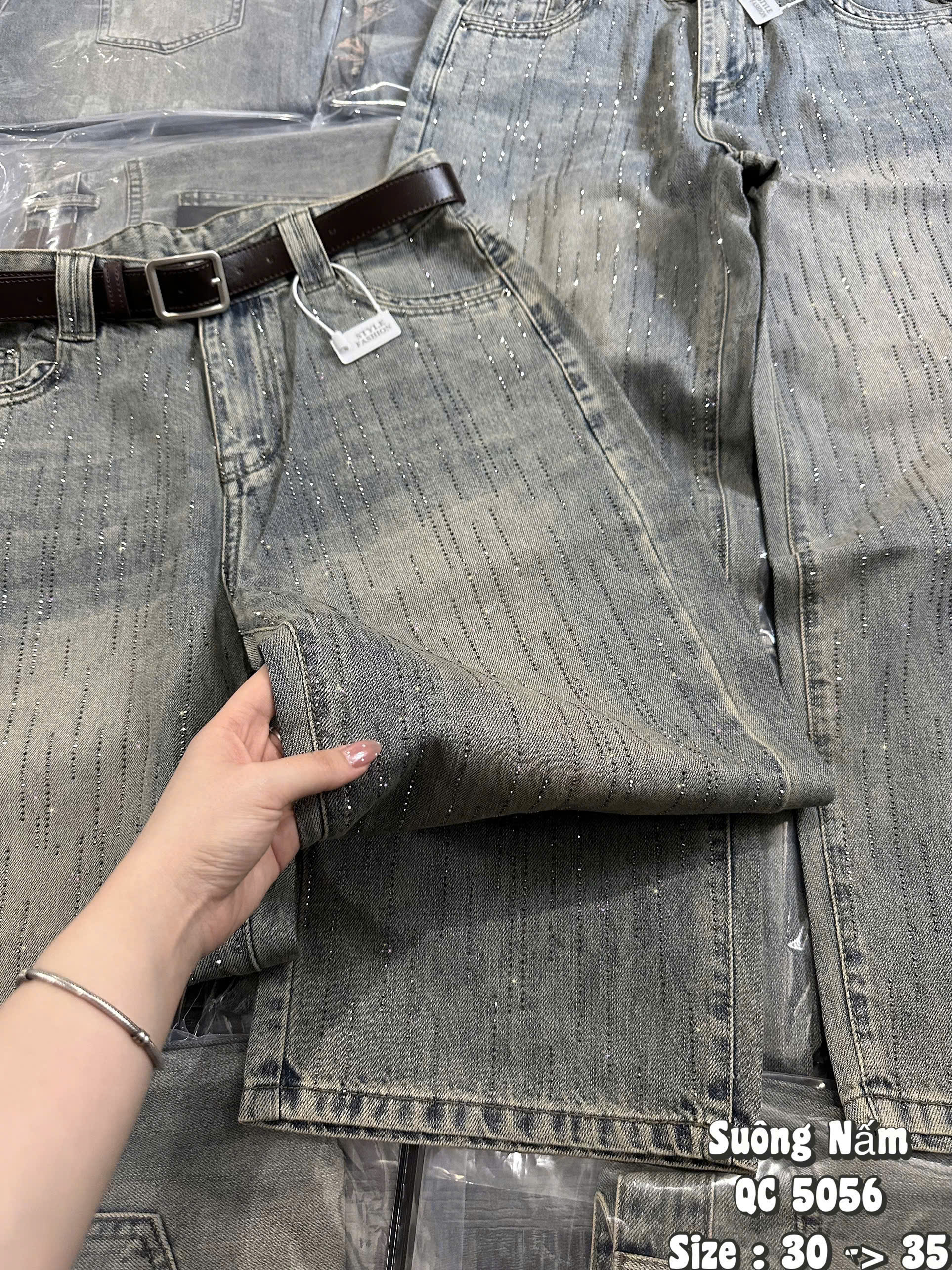 Cận bề mặt jean xước nhạt bụi và các hàng đá nhỏ trên quần T-QJ5056