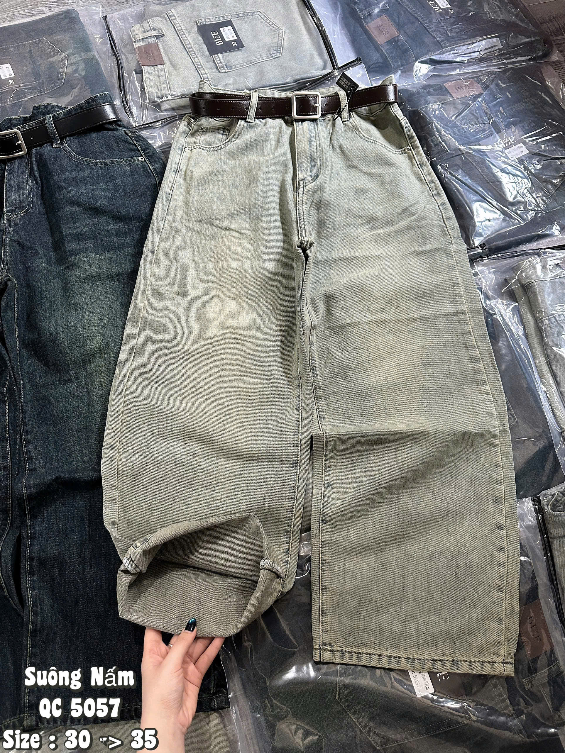 Lai quần jean T-QJ5057 màu Nhạt Bụi được lật lên, lộ mặt trái denim và đường may gấu
