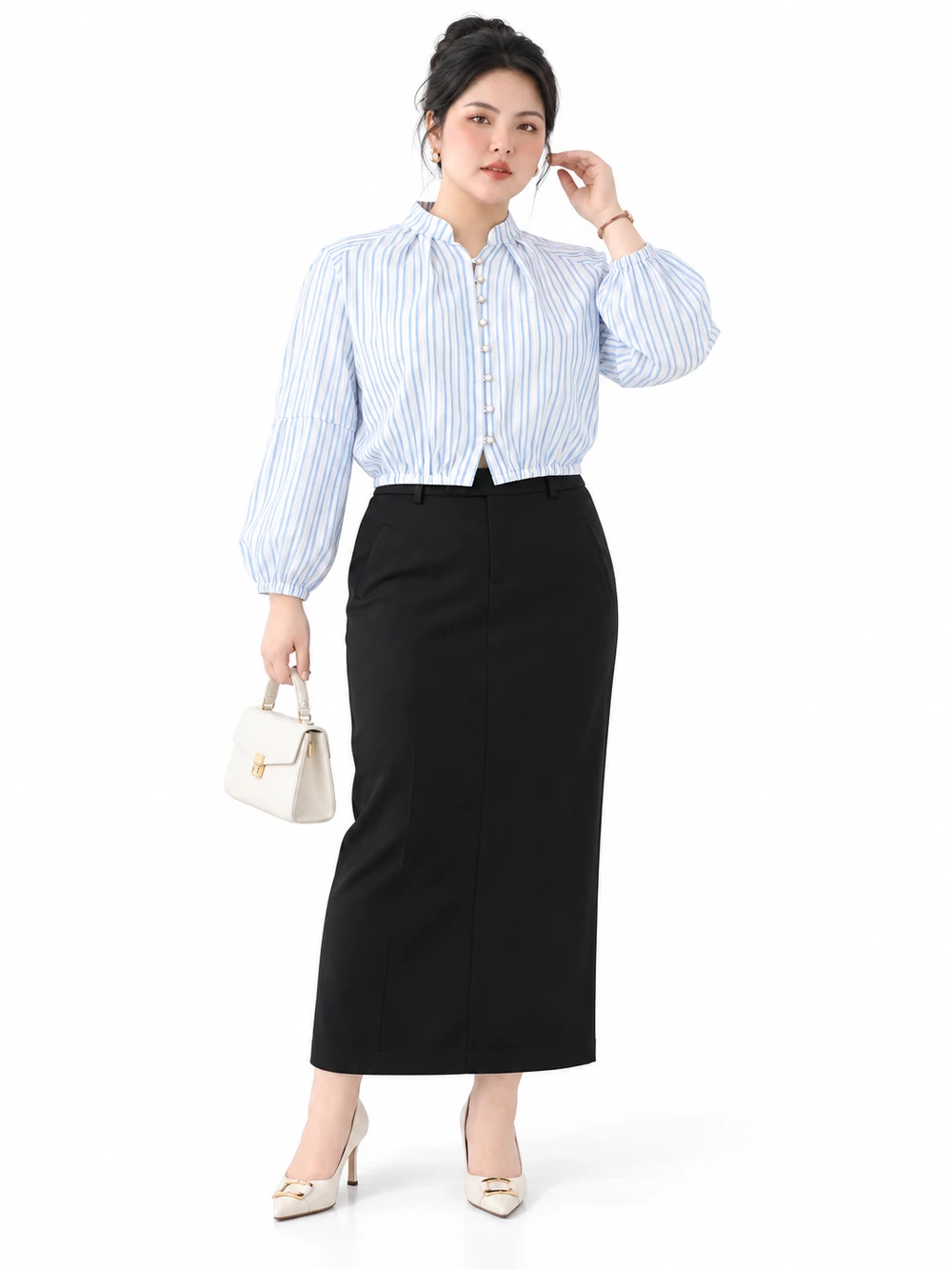 Người mẫu mặc áo V-AK138 sọc xanh trắng với chân váy đen dài, cầm túi trắng, dáng đứng mặt trước