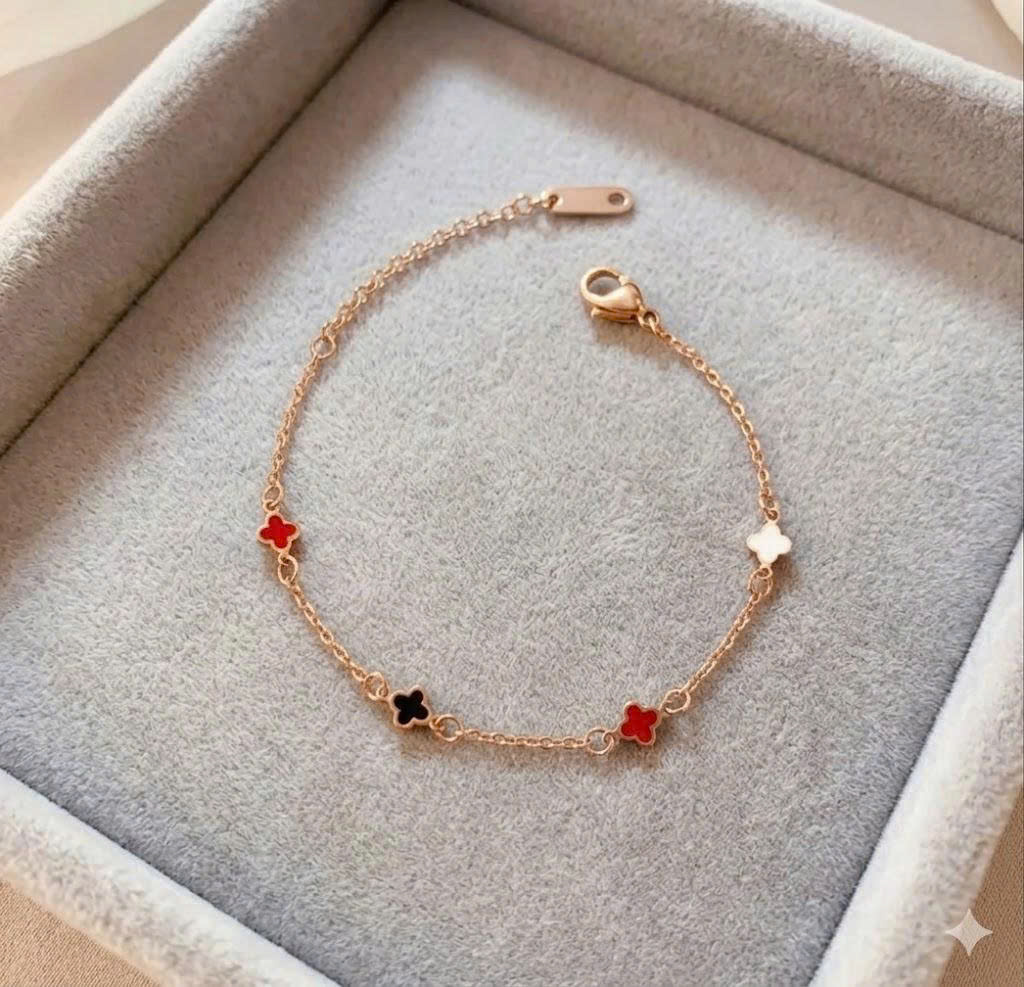 vòng tay titan màu vàng charm hoa bốn cánh đỏ trắng đen.