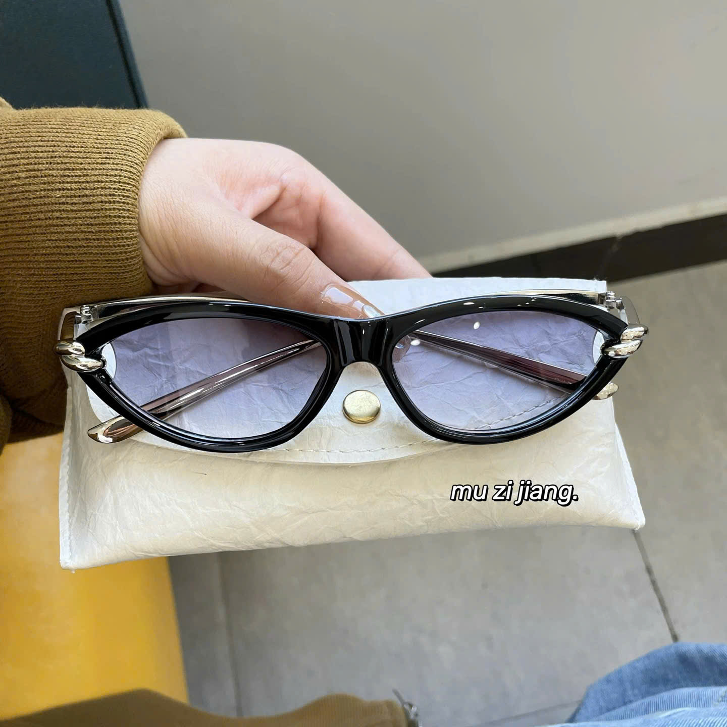 Mắt kính đen gọng thắt bạc.