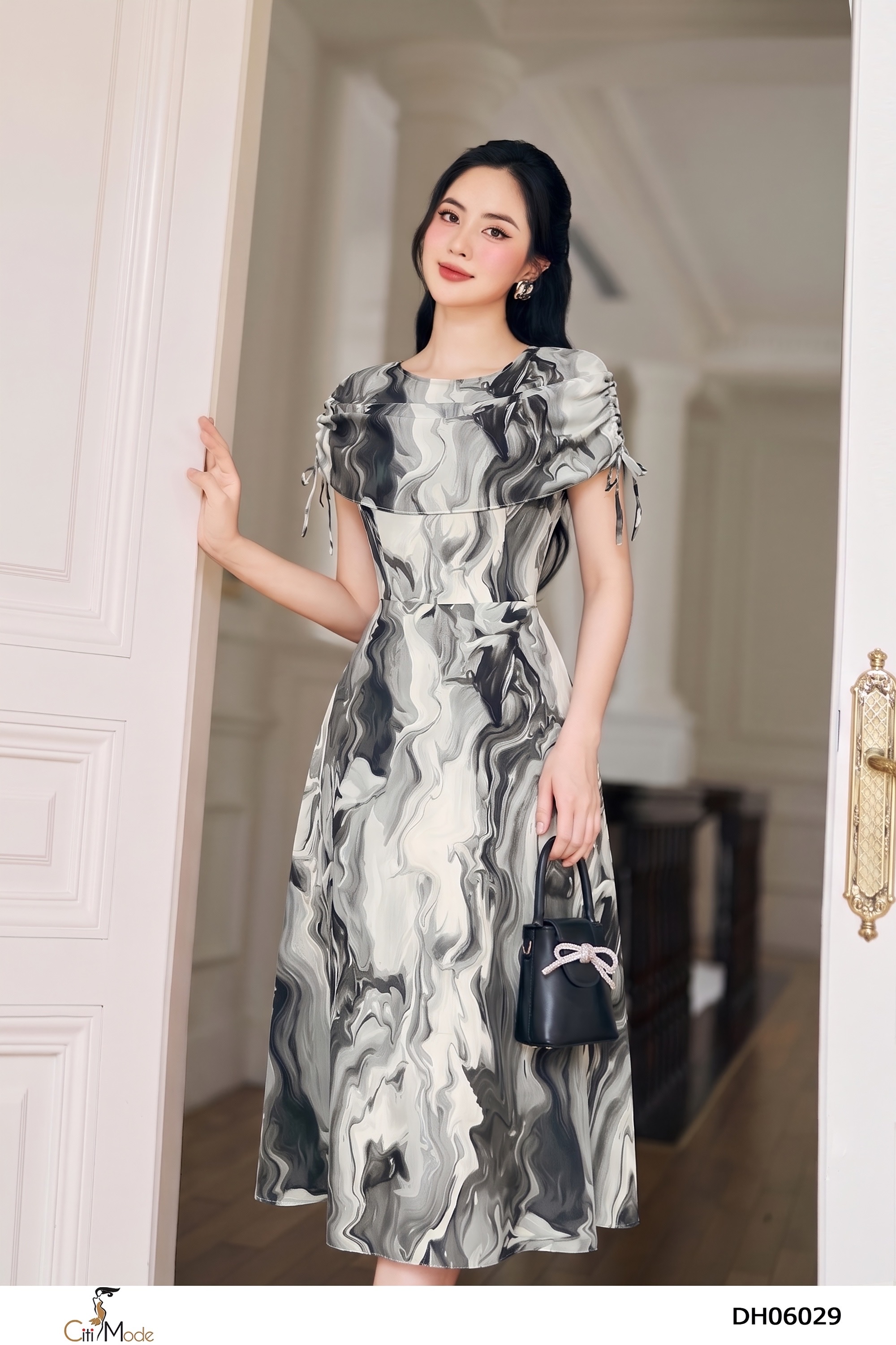 Đầm xòe họa tiết trắng đen tà phủ tay nhún thắt nơ