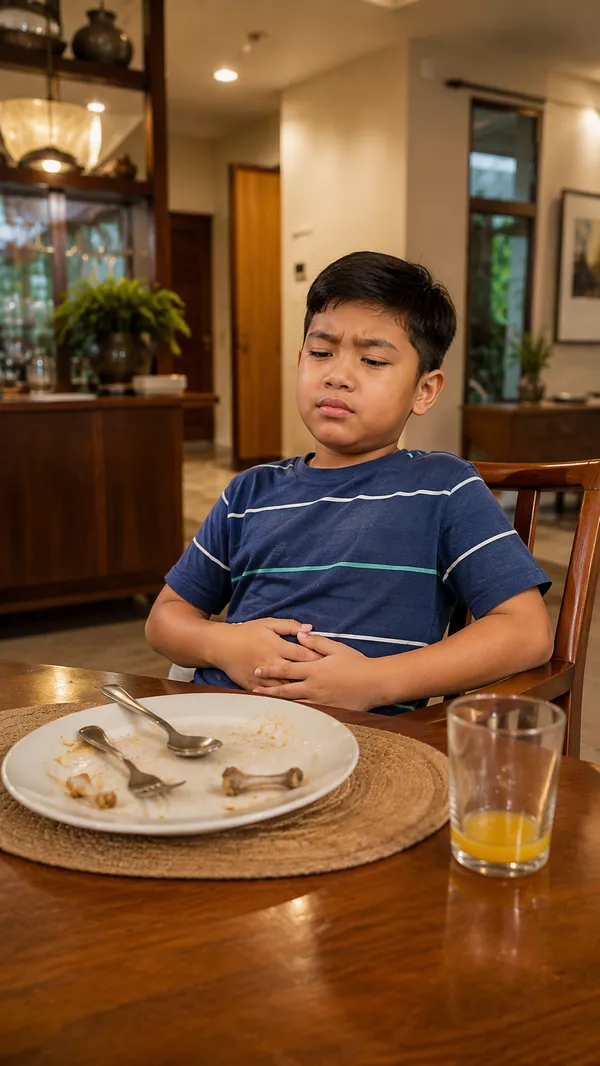 Child leaning back from the dinner table, hand on stomach