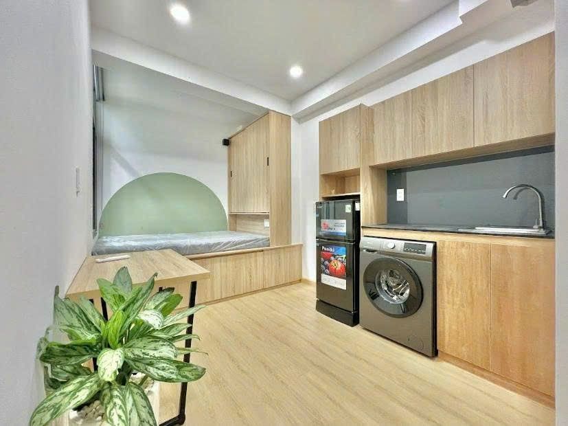 Phòng có bếp dài, tủ lạnh, máy giặt và giường bục kèm tủ áo