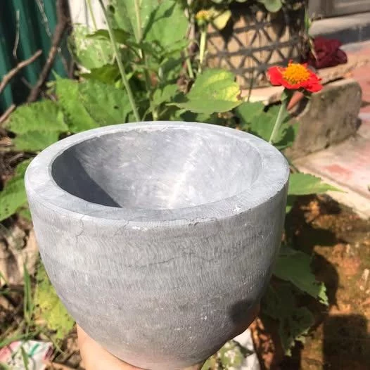 Cối đá xanh cầm trên tay