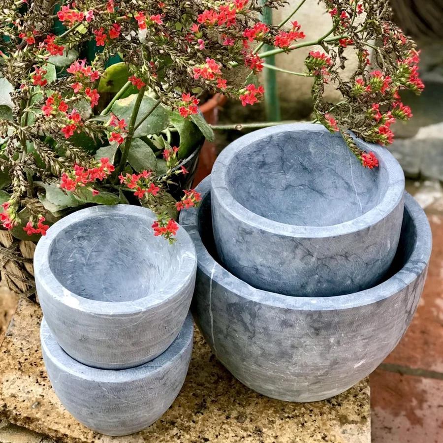 Ba chiếc cối đá xanh Ninh Bình các cỡ xếp chồng ngoài vườn