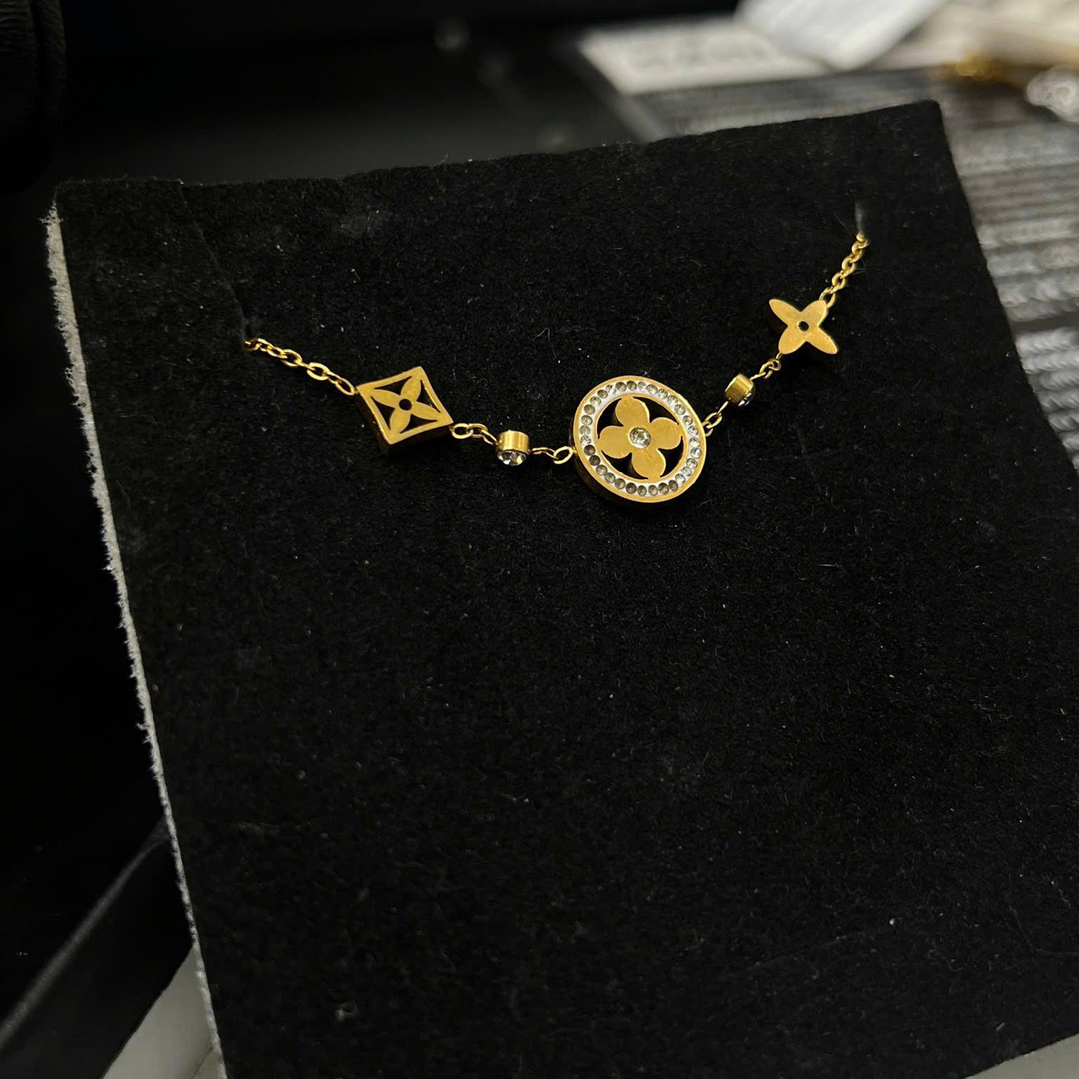 vòng tay titan vàng charm ba logo LV hoa sao 