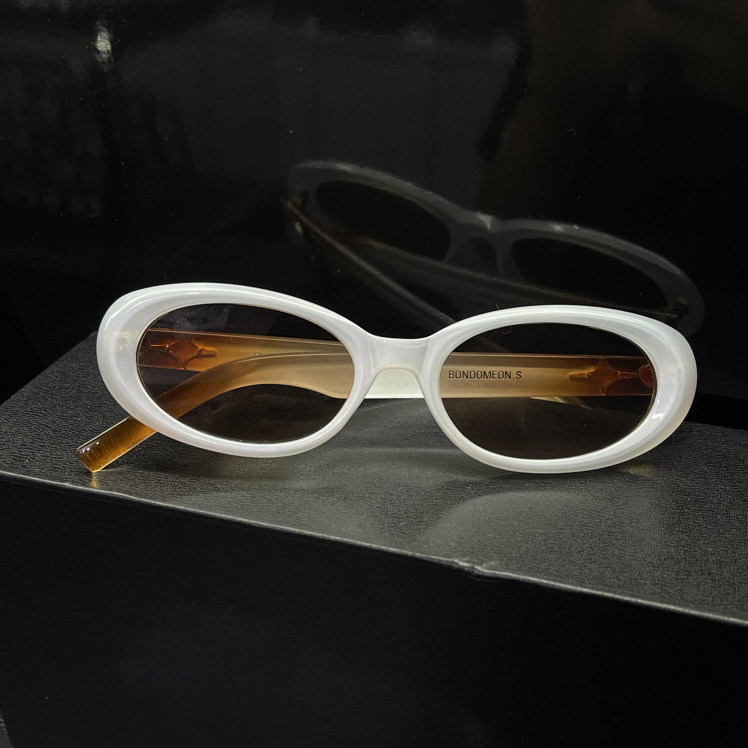 kính mắt trắng sữa mix nâu cam gọng nhựa form oval một sao.