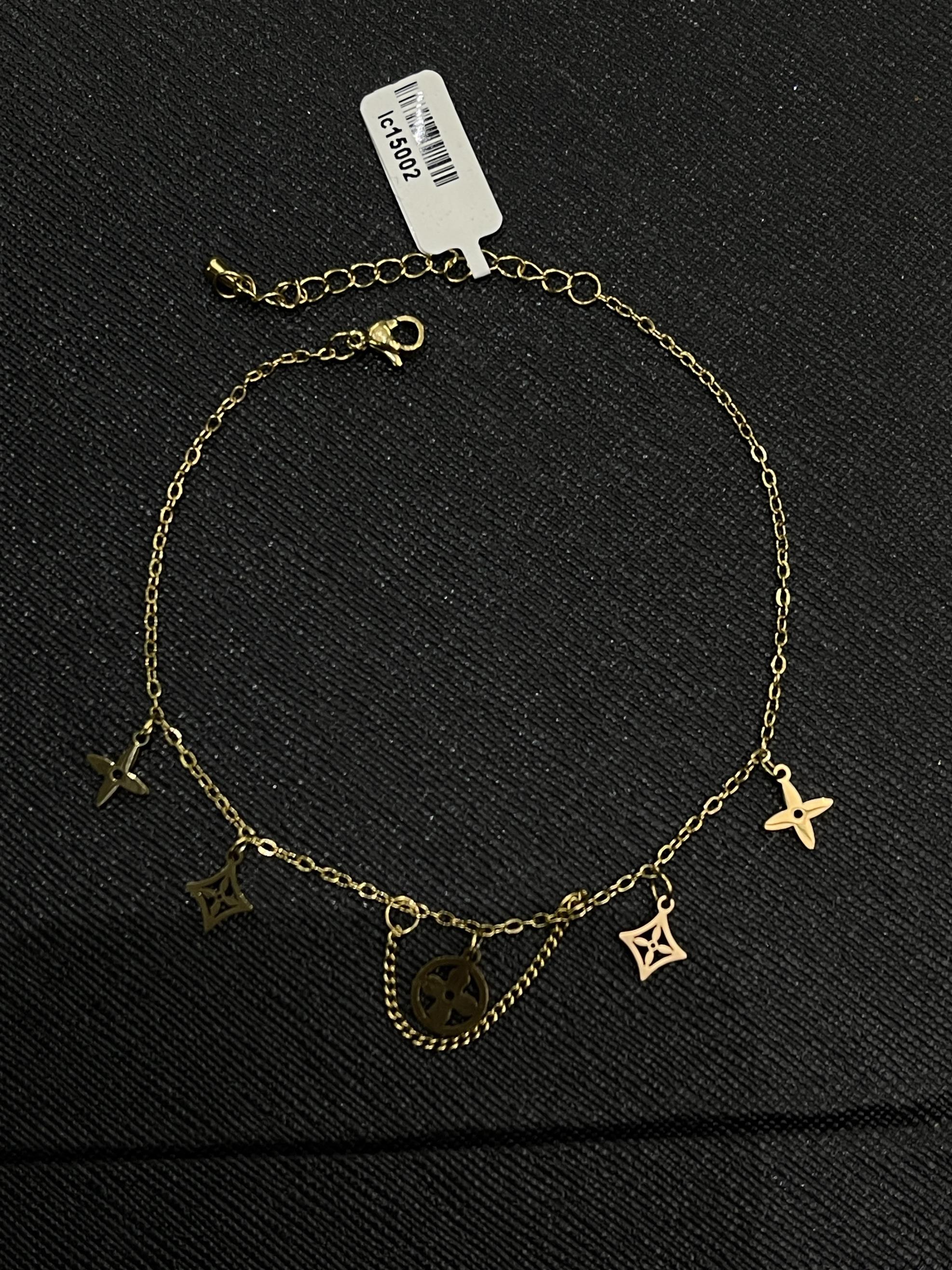 lắc chân titan charm sao bốn cánh rơi màu vàng.