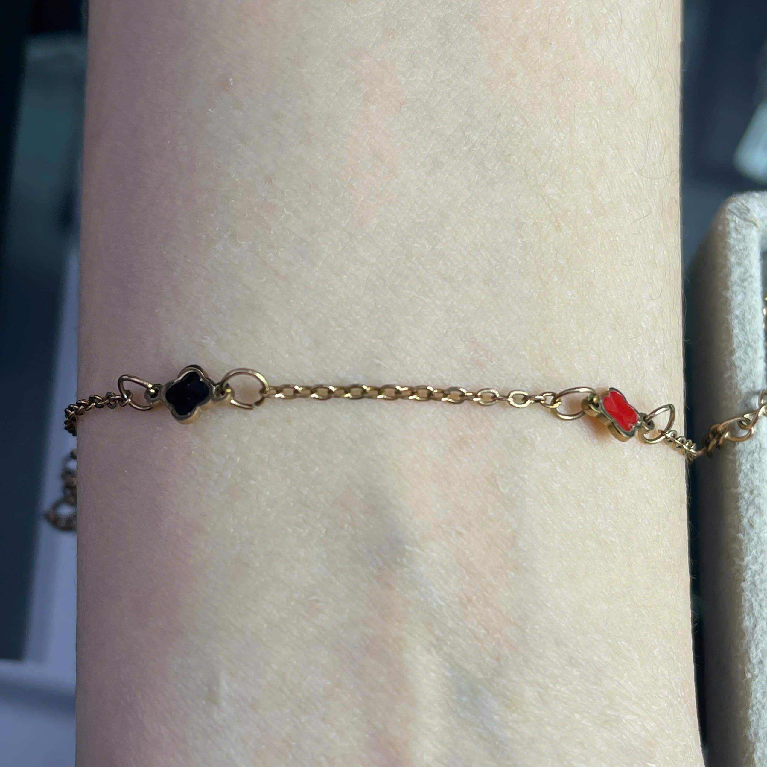 vòng tay titan màu vàng charm hoa bốn cánh đỏ trắng đen._thumbnail_2